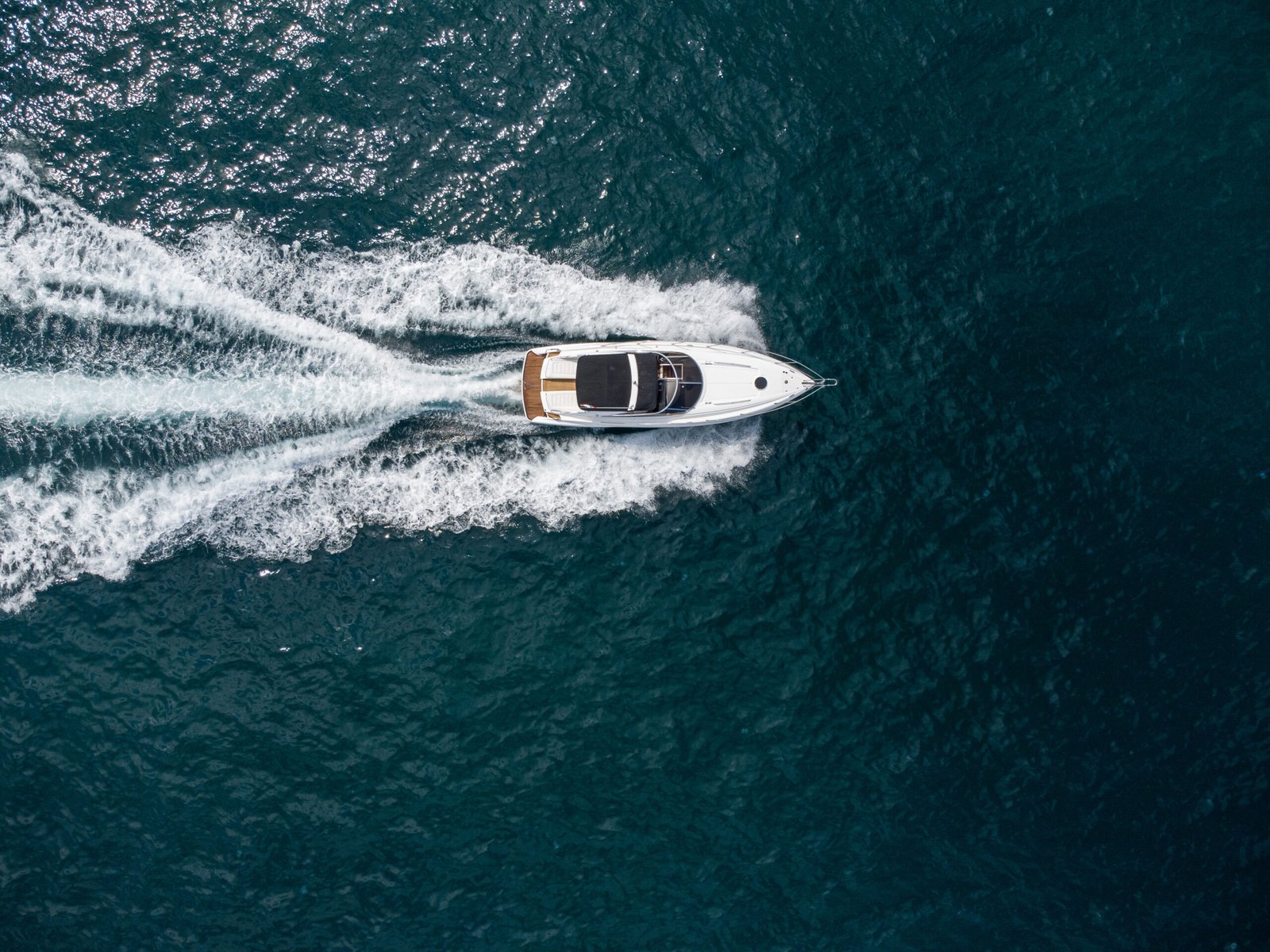 Aerial top down view of speed motor boat on open blue sea